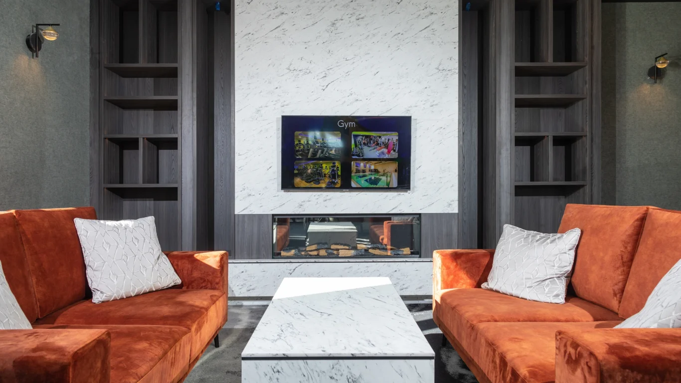 Relax in the hotel&rsquo;s cosy lounge with plush orange sofas, marble decor, and a modern fireplace. Perfect for unwinding.