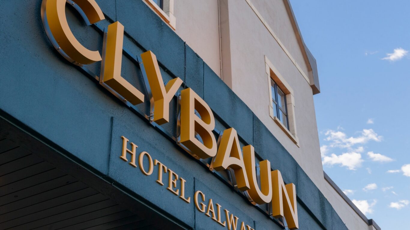 Elegant signage of Clybaun Hotel Galway against a clear blue sky, promising a welcoming stay with luxurious amenities.