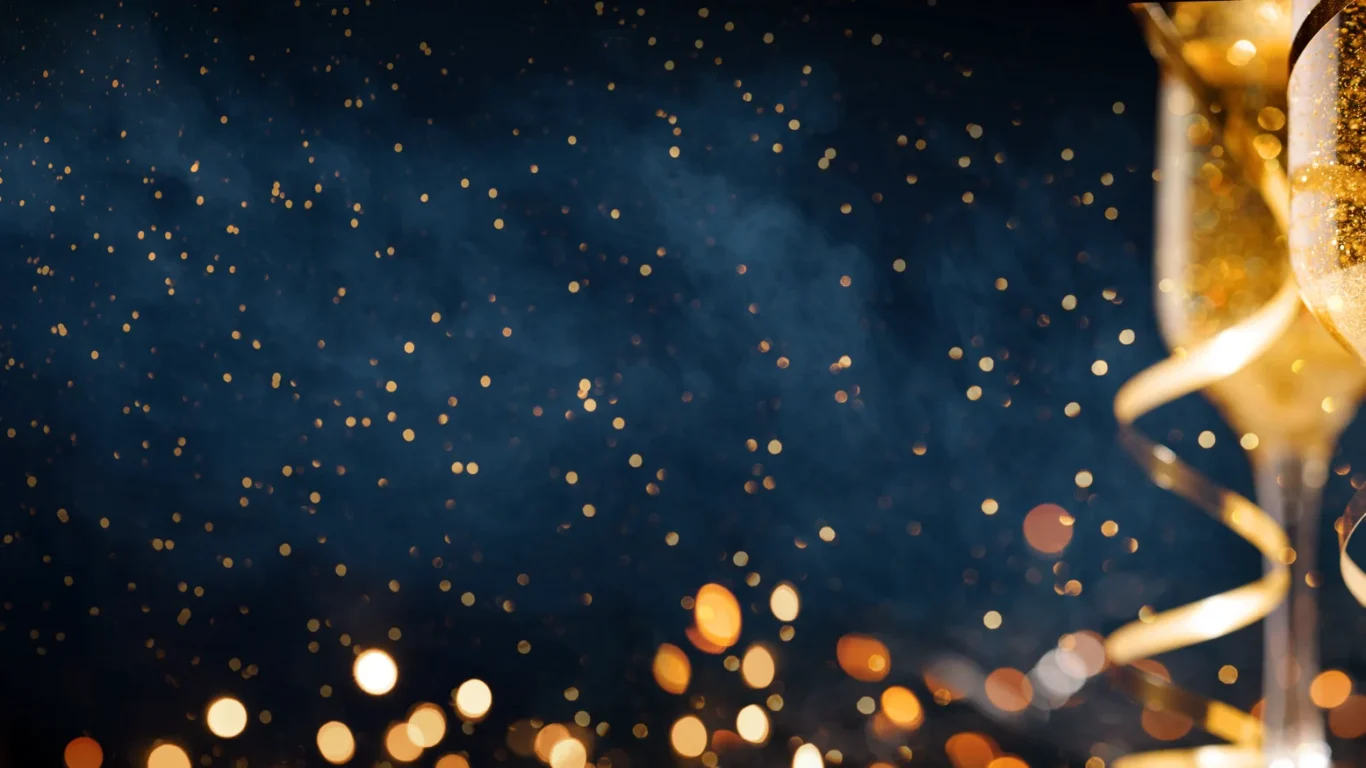 Two champagne glasses with gold ribbons and sparkling bubbles, set against a dark background with scattered golden light bokeh.