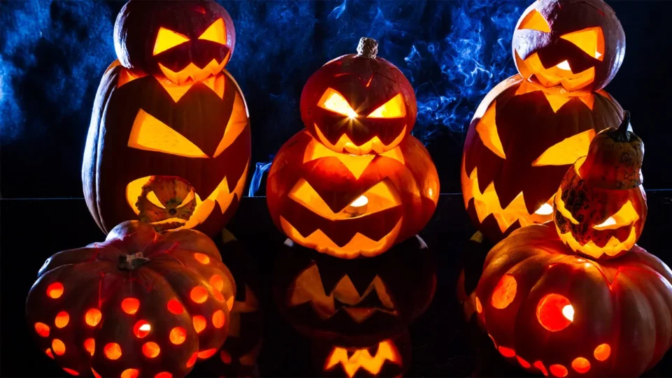 Five carved pumpkins with glowing faces and patterns are displayed against a dark, smoky background, bringing a festive touch reminiscent of the excitement at Galway Races 2025.