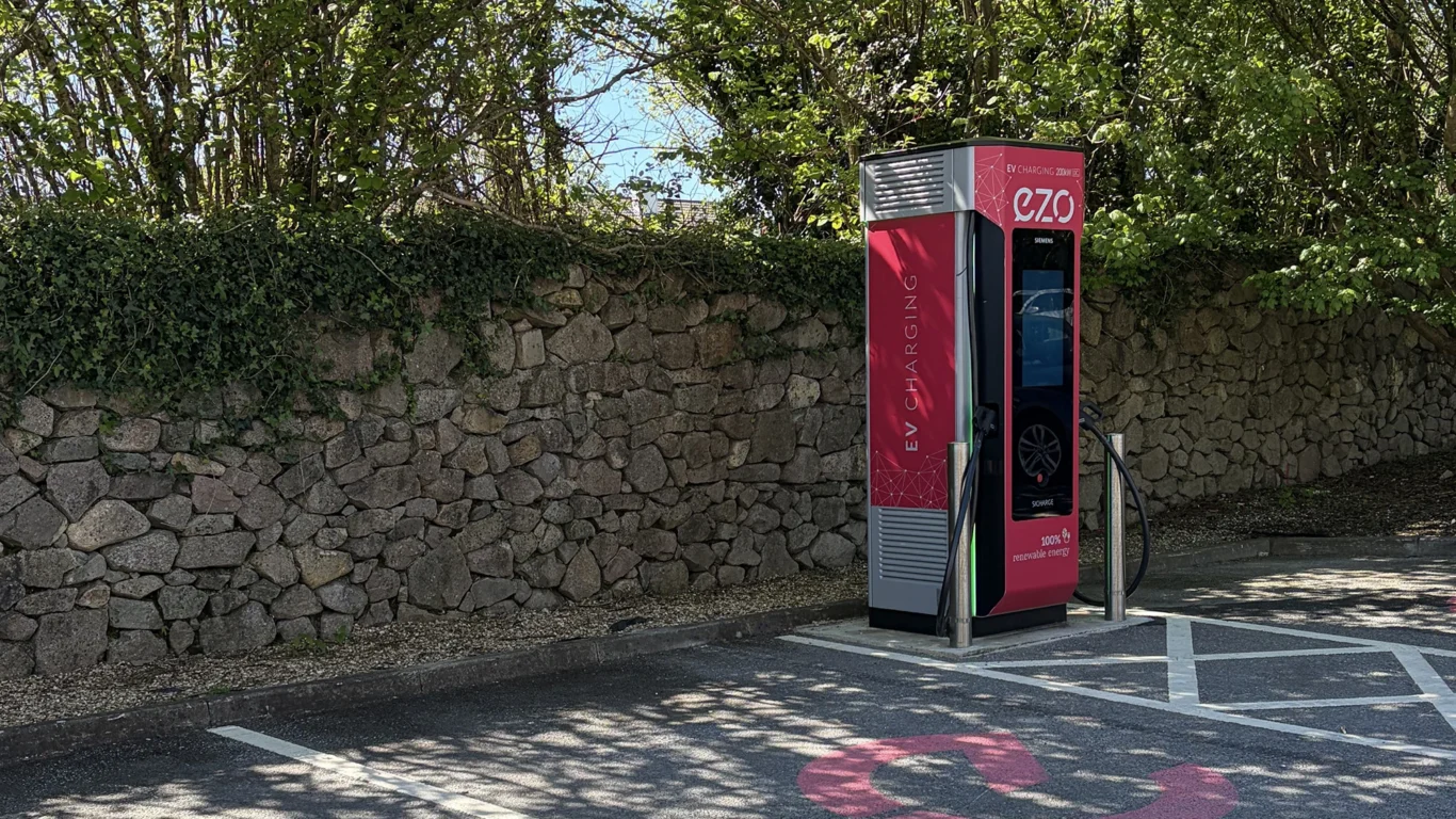 Hotel electric car charging station in a serene stone-walled area, offering eco-friendly convenience for guests.