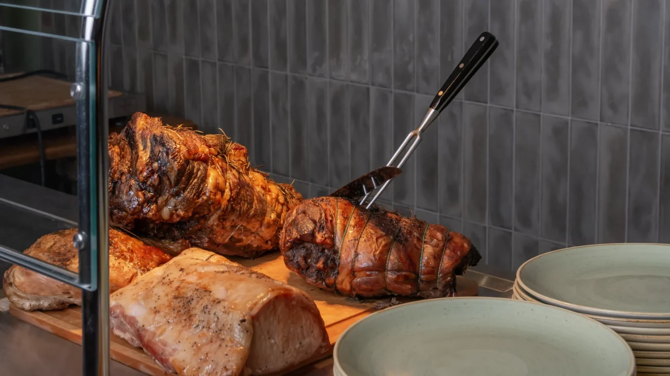 Enjoy succulent roast meats at our hotel's exquisite buffet, with a timeless and elegant dining setting.