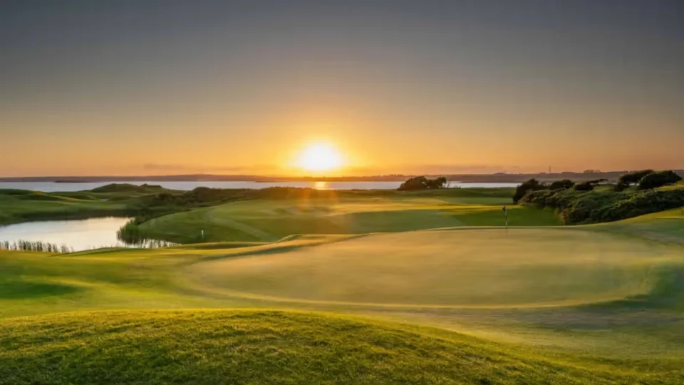 Stunning sunset view over golf course with lush green fairways and serene water, ideal for relaxing stays.