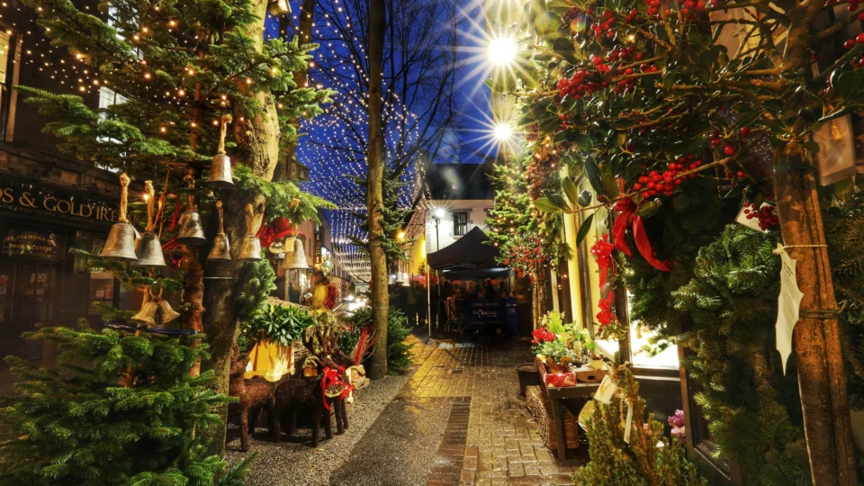 Festive hotel entrance with glowing lights, lush greenery, and welcoming atmosphere, perfect for a cosy winter getaway.